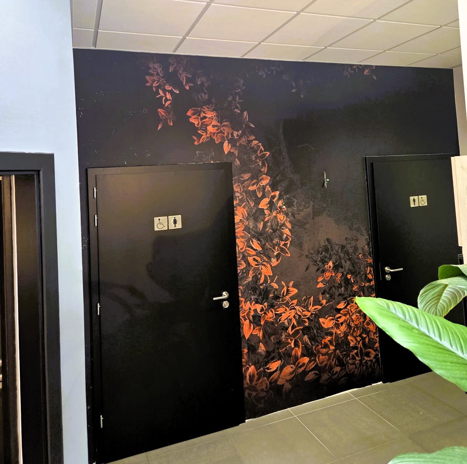 feuillage cuivré sur fond sombre dans un espace sanitaires professionnel.